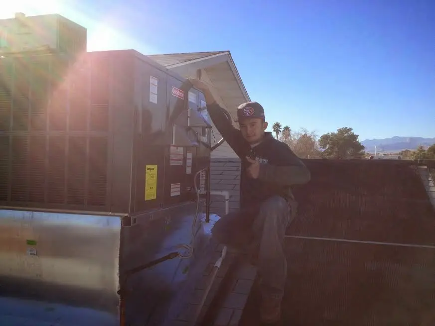 HVAC technician performing Heat Pump Repair on a rooftop unit in Franklin